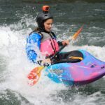 female kayaker surfing on the Santiam River in a Jackson kayak