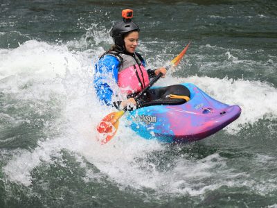 female kayaker surfing on the Santiam River in a Jackson kayak