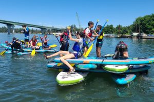 summer camp kids paddle boarding on the Willamette River