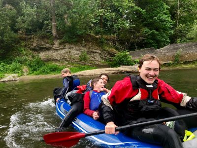 summer camp kids in an inflatable white water kayak